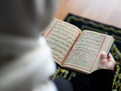 Muslim woman reading from the quran stock photo